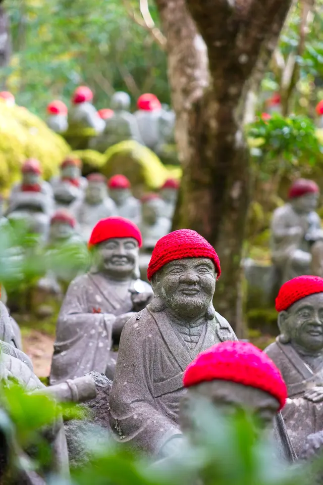 Small stone figures wearing red hats in Miyajima